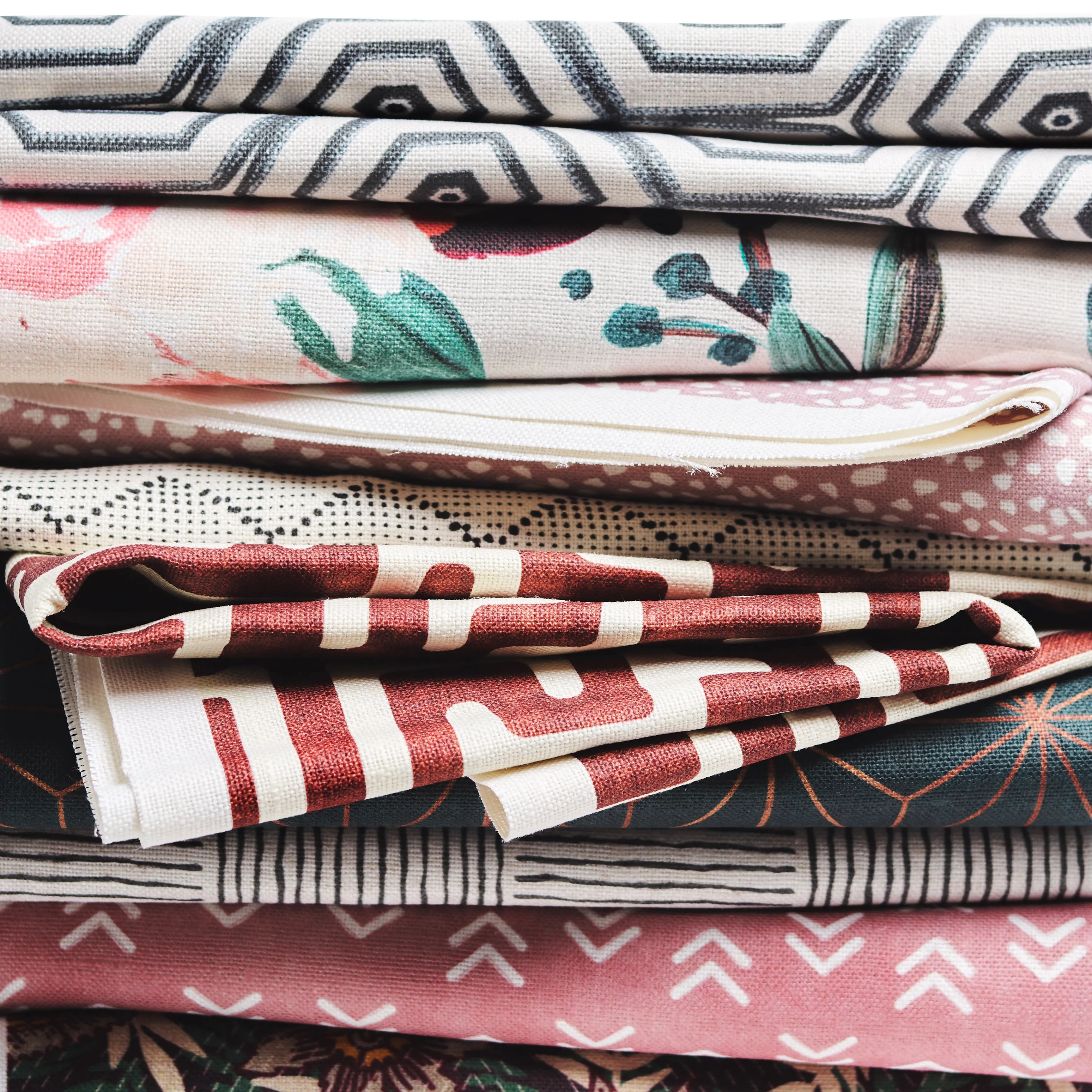 Stack of warm colored printed fabrics.
