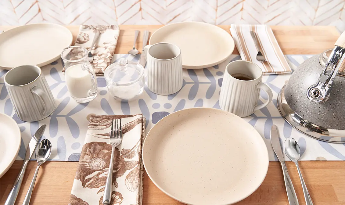 Light blue and tan botanical linens on a set dining table.