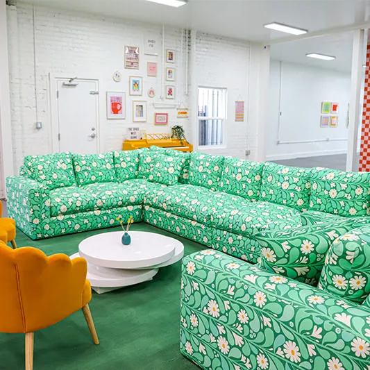 Mint green floral sectional couch in a Space Camp Organizing workspace.